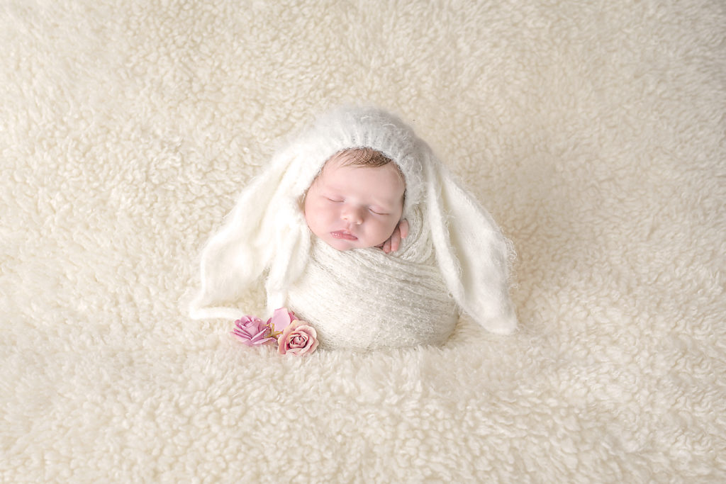 Bébé emmailloté avec un bonnet de lapin