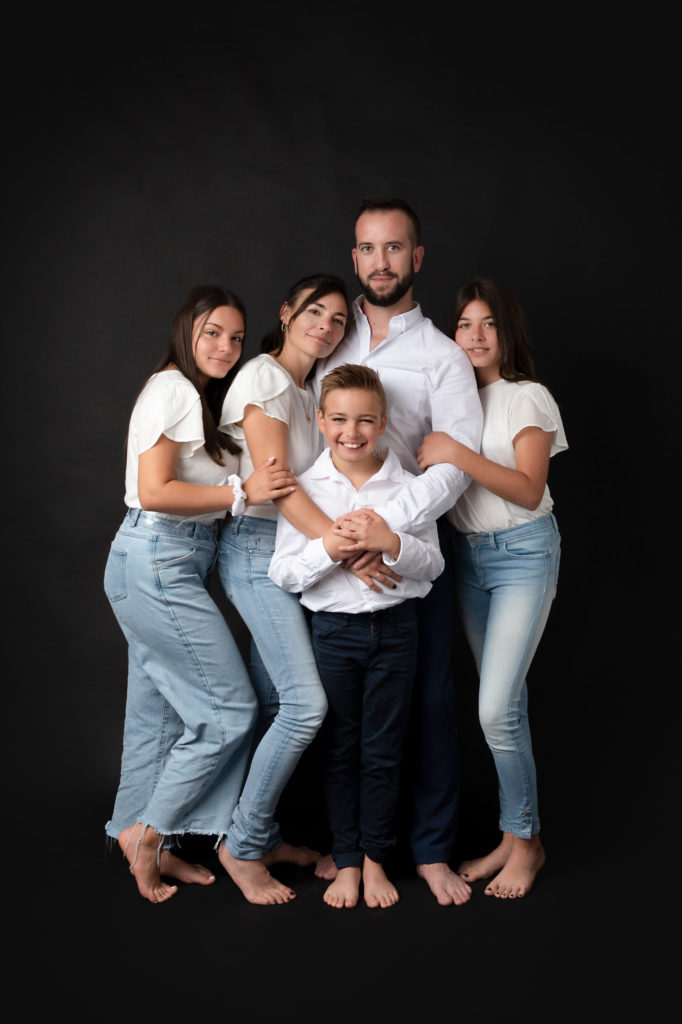 Photo de famille avec trois adolescents autour de leurs parents.