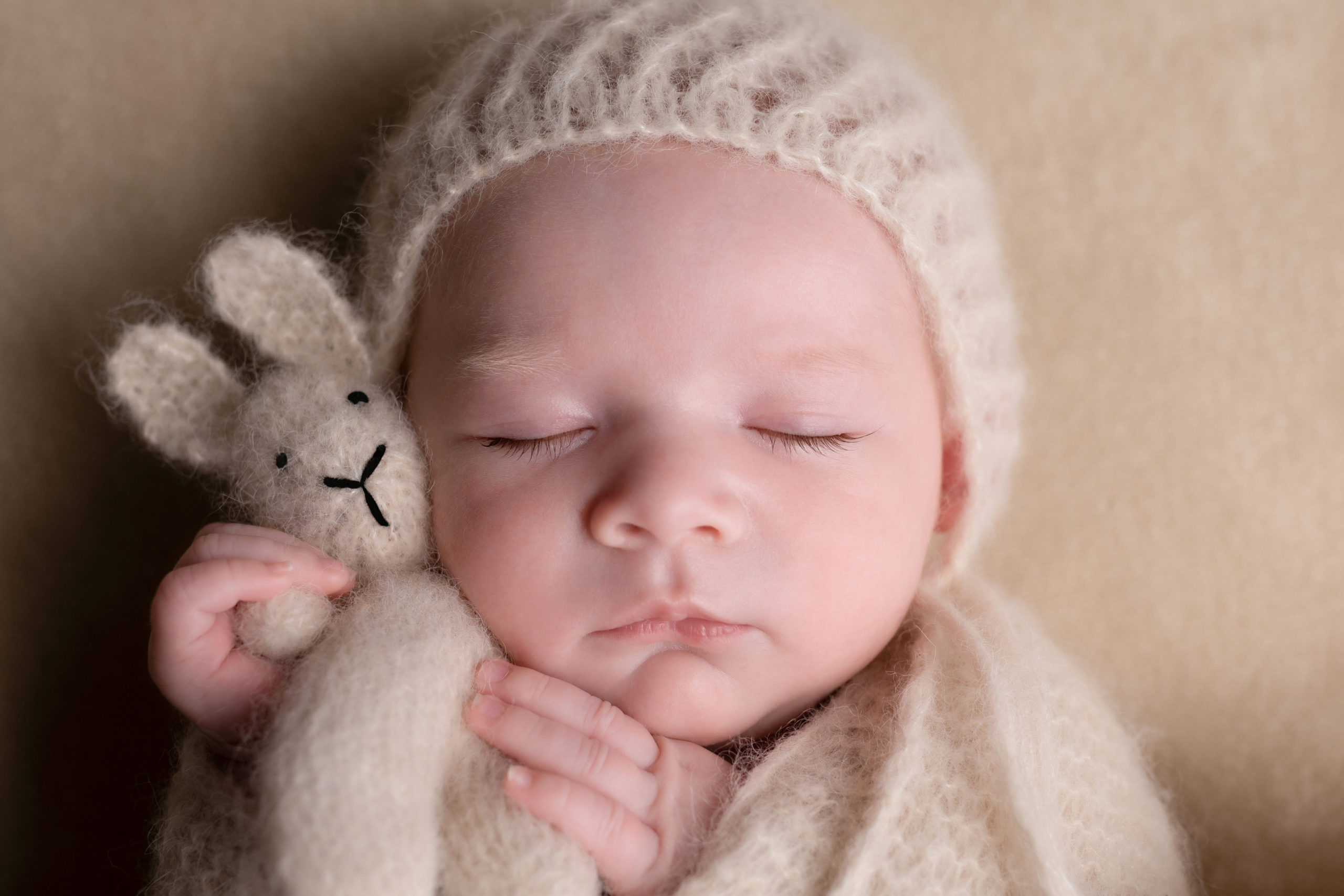 Gros plan sur un nouveau-né avec un doudou lapin dans les mains